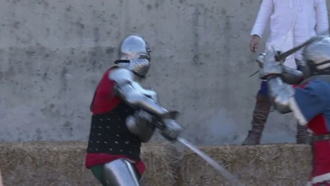Middle Ages combat. Two men dressing iron armor fight a sword-fired duel. Slomo. Video stock 76244689