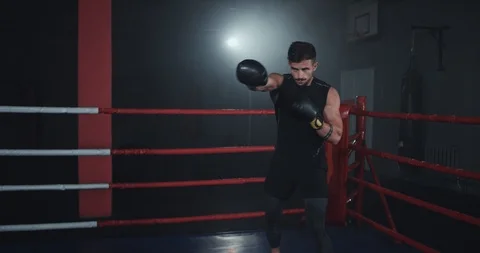 In the middle of boxing ring athletic guy with muscle boxing hard have a intense Stock Footage 117054911