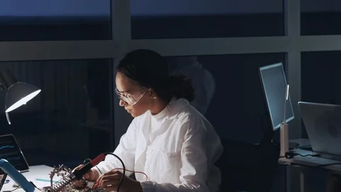 Middle close up of african american engineer making tests on motherboard in lab Stock-Footage 112877352