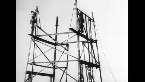 MIDDLE EAST - 1900s - Laborers constructing an oil derrick. Oil workers watch as Stock Footage 316679850