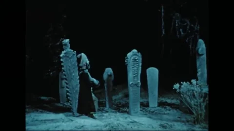 MIDDLE EAST - 1950s - Hoja keeps vigil beside a headstone in the cemetery at Stock Footage 328191205