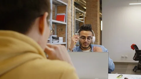 Middle Easter Man with Headphones Speaking with Colleague at Work Vidéo 126135665