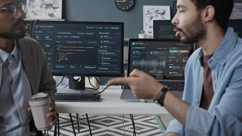 Middle Eastern and Indian Male Developers Collaborating on Software in Office Stock Footage 337481933