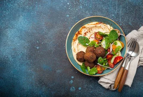 Middle Eastern Arab meal with fried falafel, hummus, vegetables salad space for Foto stock