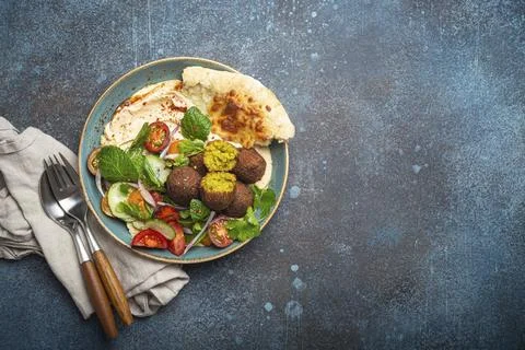 Middle Eastern Arab meal with fried falafel, hummus, vegetables salad with fresh Stock Photos