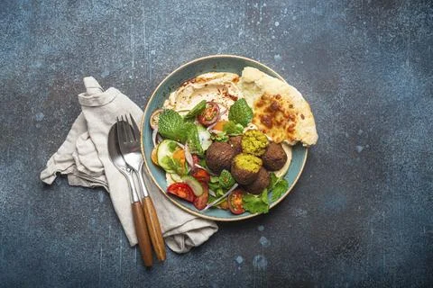 Middle Eastern Arab meal with fried falafel, hummus, vegetables salad with fresh Stock Photos