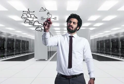 Middle Eastern businessman drawing cloud network diagram in modern data center Stock Photos