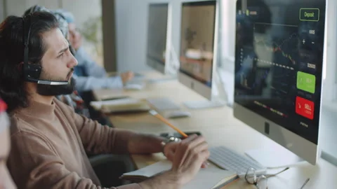 Middle Eastern Businessman in Headset Using Computer and Taking Notes Stock Footage 152387128