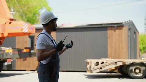 Middle eastern construction site manager guiding prefabricated house module Stock Footage 316716400