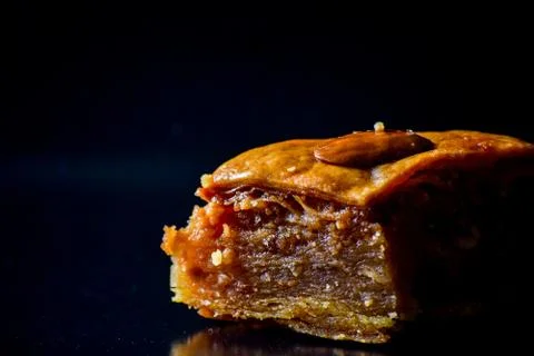 Middle Eastern dessert called mabroume or bahlava isolated on black backgroun Stock Photos