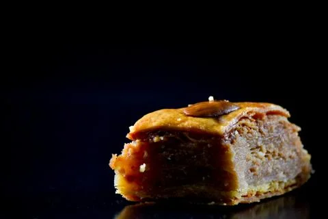 Middle Eastern dessert called mabroume or bahlava isolated on black backgroun Stock Photos