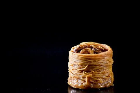 Middle Eastern dessert called mabroume or burma isolated on black background. Stock Photos