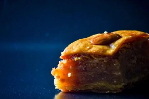 Middle Eastern dessert called mabroume or bahlava isolated on black backgroun Stock Photos