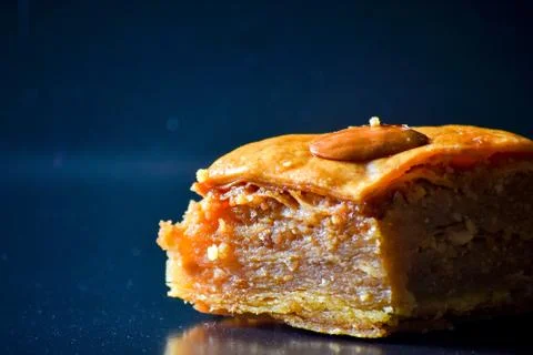Middle Eastern dessert called mabroume or bahlava isolated on black backgroun Stock Photos