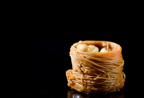 Middle Eastern dessert called mabroume or burma isolated on black background. Stock Photos
