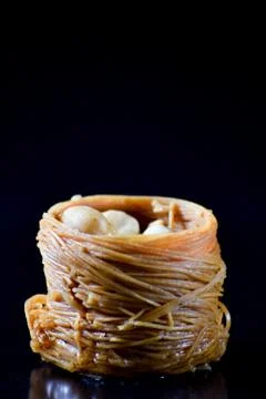 Middle Eastern dessert called mabroume or burma isolated on black background. Stock Photos