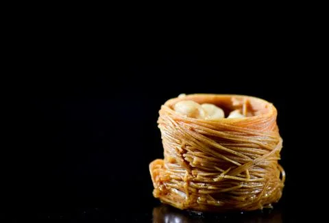 Middle Eastern dessert called mabroume or burma isolated on black background. Stock Photos