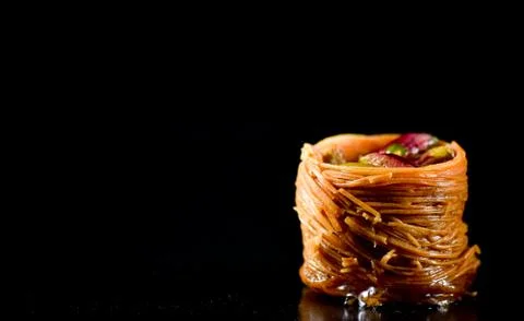 Middle Eastern dessert called mabroume or burma isolated on black background. Stock Photos