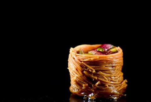 Middle Eastern dessert called mabroume or burma isolated on black background. Stock Photos