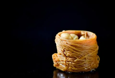 Middle Eastern dessert called mabroume or burma isolated on black background. Stock Photos