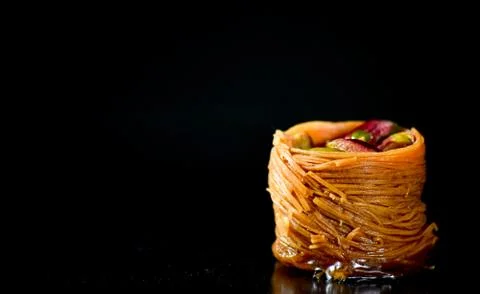 Middle Eastern dessert called mabroume or burma isolated on black background. Stock Photos