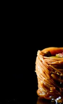 Middle Eastern dessert called mabroume or burma isolated on black background. Stock Photos