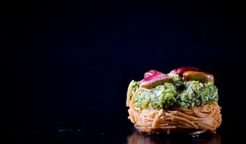 Middle Eastern dessert called mabroume or burma isolated on black background. Stock Photos