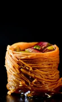 Middle Eastern dessert called mabroume or burma isolated on black background. Stock Photos
