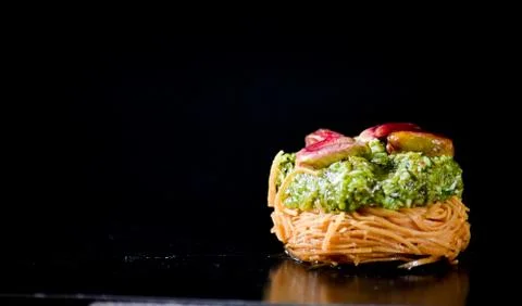 Middle Eastern dessert called mabroume or burma isolated on black background. Stock Photos