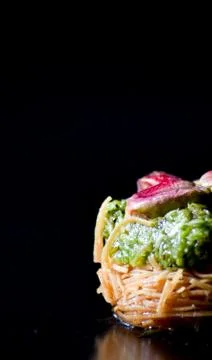 Middle Eastern dessert called mabroume or burma isolated on black background. Stock Photos