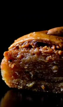 Middle Eastern dessert called mabroume or bahlava isolated on black backgroun Stock Photos