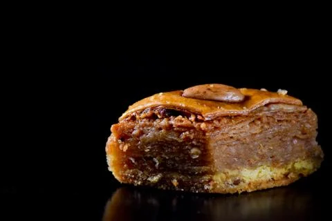 Middle Eastern dessert called mabroume or bahlava isolated on black backgroun Stock Photos