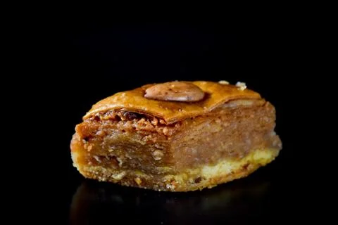 Middle Eastern dessert called mabroume or bahlava isolated on black backgroun Stock Photos