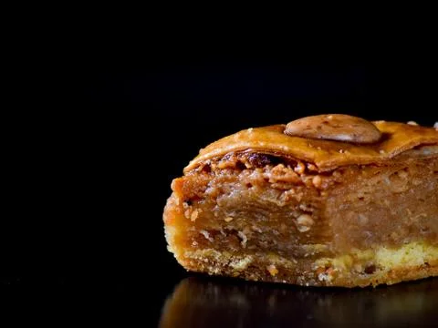 Middle Eastern dessert called mabroume or bahlava isolated on black backgroun Stock Photos