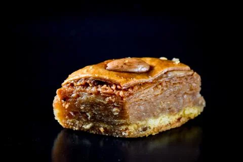 Middle Eastern dessert called mabroume or bahlava isolated on black backgroun Stock Photos