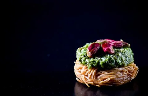 Middle Eastern dessert called mabroume or burma isolated on black background. Stock Photos