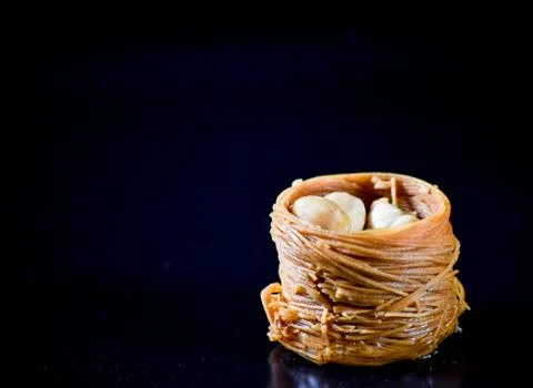 Middle Eastern dessert called mabroume or burma isolated on black background. Stock Photos