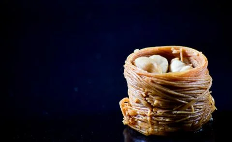 Middle Eastern dessert called mabroume or burma isolated on black background. Stock Photos