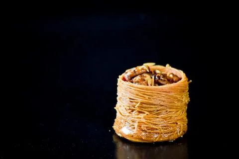 Middle Eastern dessert called mabroume or burma isolated on black background. Stock Photos