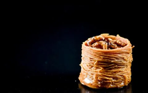 Middle Eastern dessert called mabroume or burma isolated on black background. Stock Photos
