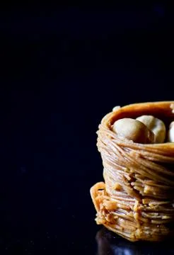 Middle Eastern dessert called mabroume or burma isolated on black background. Stock Photos
