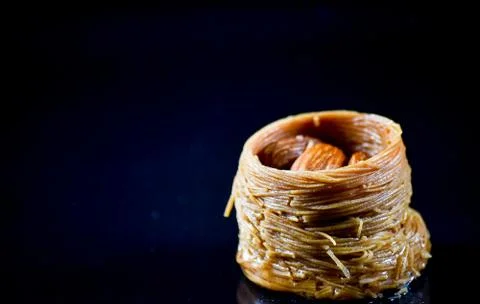 Middle Eastern dessert called mabroume or burma isolated on black background. Stock Photos