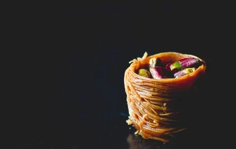 Middle Eastern dessert called mabroume or burma isolated on black background. Stock Photos