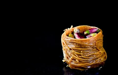 Middle Eastern dessert called mabroume or burma isolated on black background. Stock Photos