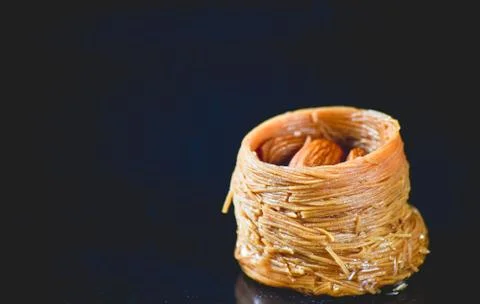 Middle Eastern dessert called mabroume or burma isolated on black background. Stock Photos