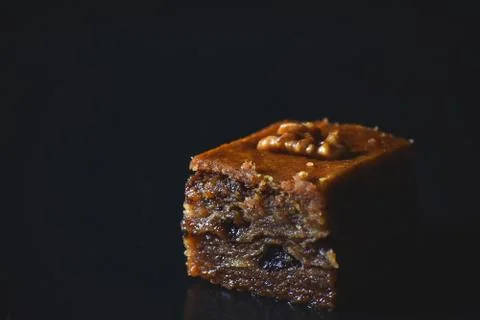 Middle Eastern dessert called mabroume or bahlava isolated on black backgroun Stock Photos
