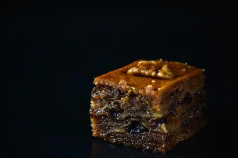 Middle Eastern dessert called mabroume or bahlava isolated on black backgroun Stock Photos