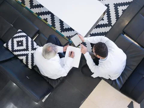 Middle Eastern doctors consulting patient notes and tablet in modern hospital Stock Photos