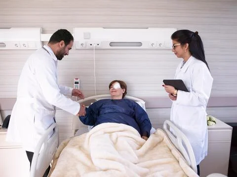 Middle Eastern doctors greeting and examining a recovering patient with eye Stock Photos
