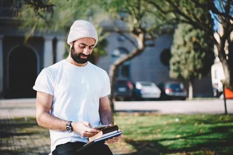 Middle Eastern hipster guy making online booking and banking via cellphone Stock Photos